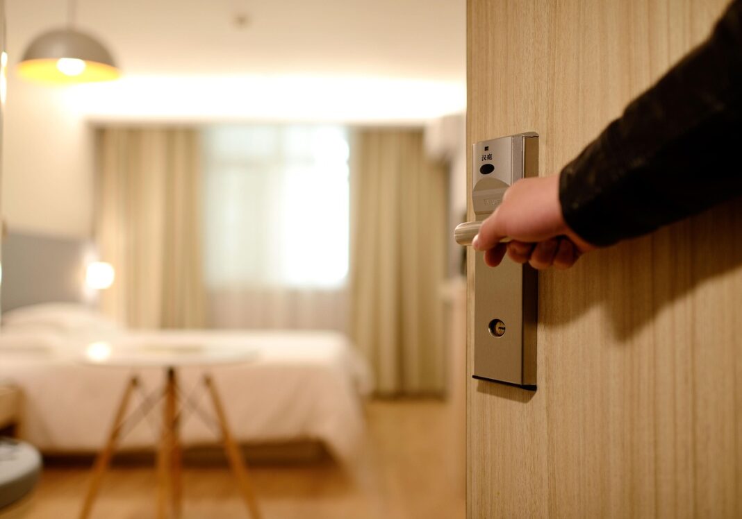 o cameră de hotel vazuta din ușa întredeschisă